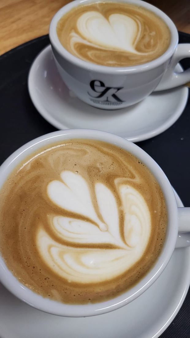 Zwei Cappuccino von oben, beide mit einem Muster aus Milchschaum in der Crema